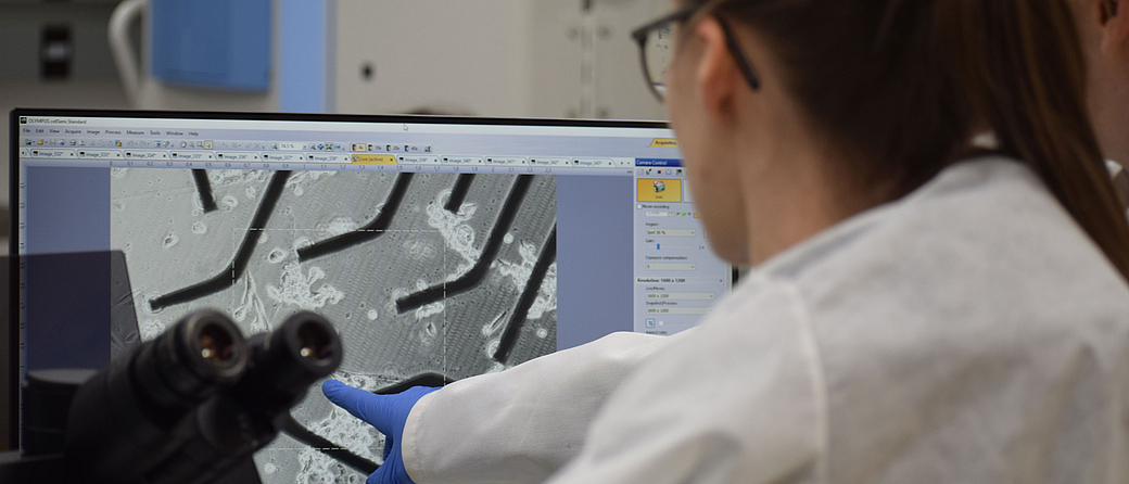 Checking the cells on multi-electrode arrays under the microscope at the Space Station Processing Facility at Kennedy Space Center. 