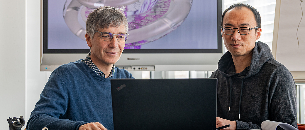 Prof. Dr. Werner Hemmert and Dr. Siwei Bai have developed a computer model which predicts the neuronal activation patterns that cochlea implants create in the auditory nerve. Image: Andreas Heddergott / TUM