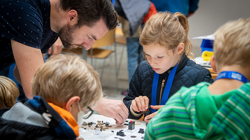 Besucher:innen beim Bauen eines Forschungsgeräts als Legomodell. Bild: Andreas Heddergott / TUM