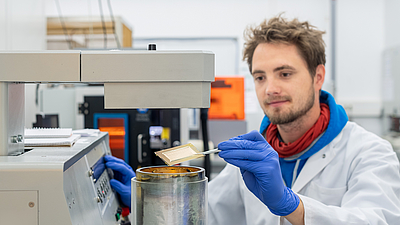 Lukas Hiendlmeier, der ihm Rahmen seiner Doktorarbeit an dem Projekt forscht, beim Bearbeiten der sich selbstfaltenden Elektroden.