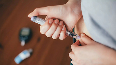Eine Frau bei der Injektion mit einem Insulinpen