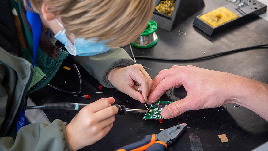 Bei der Aktion 'Türen auf mit der Maus' löteten Kinder unter Anleitung elektronische Würfel, kleine Musikinstrumente und weitere Bausätze. Bild: Andreas Heddergott / TUM Bei der Aktion 'Türen auf mit der Maus' löteten Kinder unter Anleitung elektronische Würfel, kleine Musikinstrumente und weitere Bausätze. Bild: Andreas Heddergott / TUM