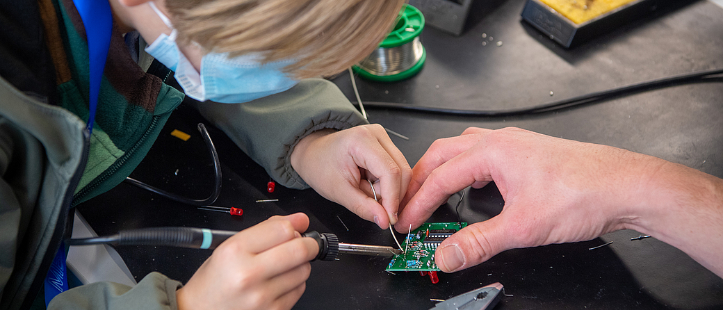 Bei der Aktion 'Türen auf mit der Maus' löteten Kinder unter Anleitung elektronische Würfel, kleine Musikinstrumente und weitere Bausätze. Bild: Andreas Heddergott / TUM