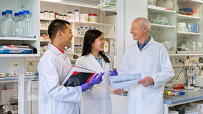 Bioanalyst Professor Bernhard Küster (right side) in the laboratory together with two researchers.