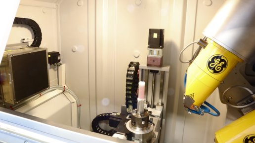 Blick in die Abschirmkabine des microCT Geräts „vltomelx“, mit dem Röntgen-Flächendetektor zur Linken, einer Probe in der Mitte und zwei Röntgenröhren rechts.  Bild: Klaus Achterhold / TUM