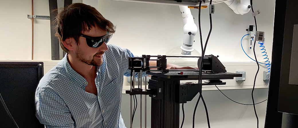Jakob Lingg arbeitet er an seinem Laser-Scanning-Mikroskop, mit dem er Dynamiken mit hoher räumlicher und zeitlicher Auflösung tief im lebenden Gewebe abbilden möchte (Bild: Jakob Lingg)